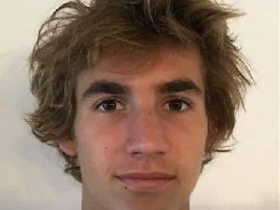 headshot of a young man with brown hair and brown eyes.