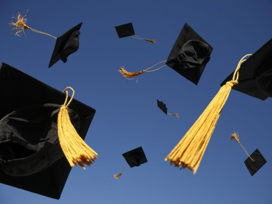 graduation caps in the air.